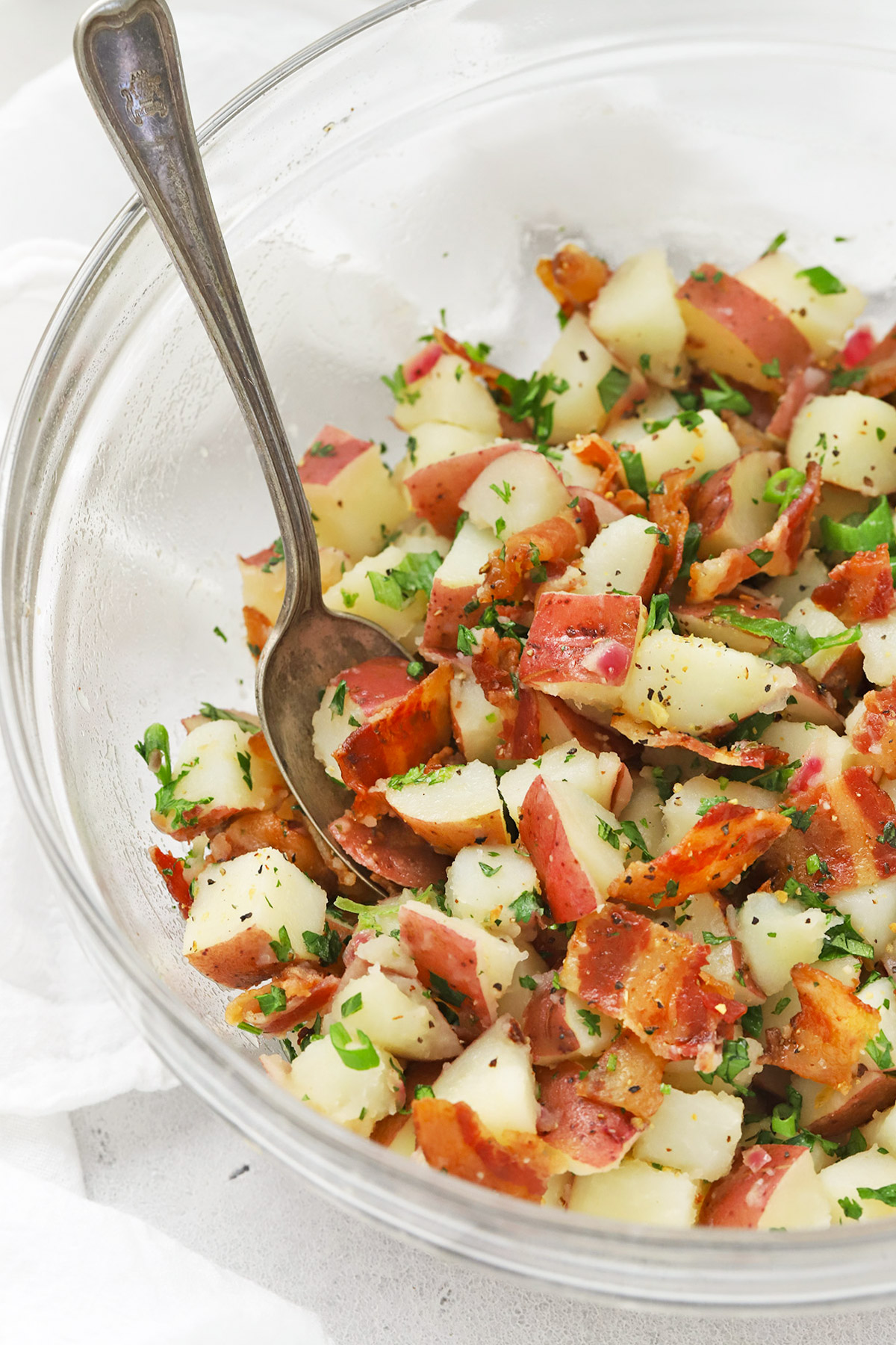 Front view of a glass bowl of German Potato Salad with Bacon Dressing