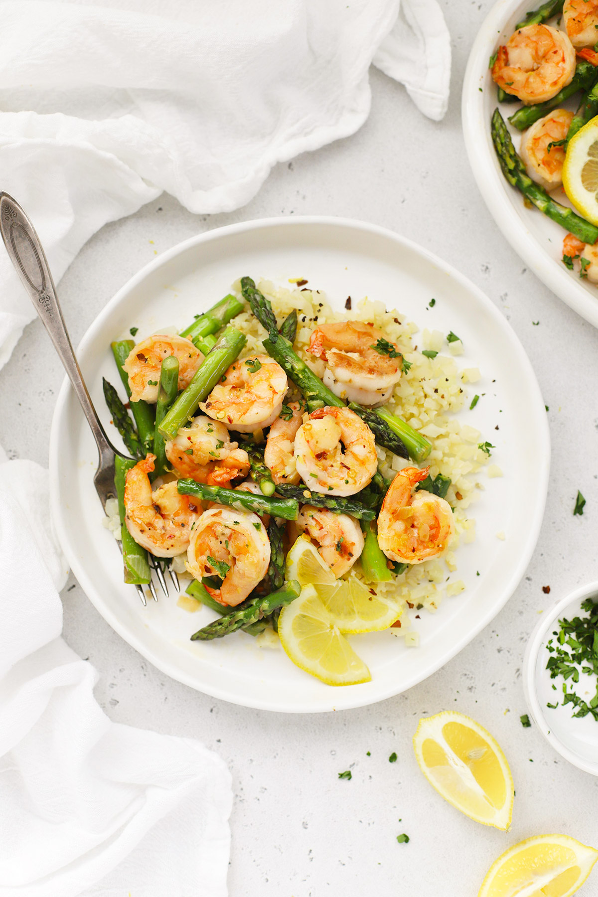 Overhead view of a plate of lemon shrimp and asparagus with cauliflower rice