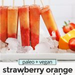 Front view of strawberry orange sunrise popsicles standing up in ice with text overlay that reads "paleo & vegan Strawberry Orange Sunrise Popsicles: Easy + Healthy + Fresh"