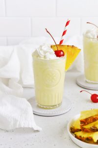 Front view of a virgin pina colada with whipped cream and a cherry on a white background