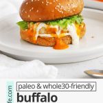 Front view of a buffalo chicken burger on a gluten-free bun with lettuce, buffalo sauce, and paleo ranch with text overlay that reads "paleo + whole30-friendly buffalo chicken burgers: quick + easy + healthy"
