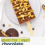 Overhead view of a chocolate peanut butter popsicle drizzled with natural peanut butter and sprinkled with crushed peanuts with text overlay that reads "gluten-free + vegan chocolate peanut butter popsicles: creamy + healthy + lovely"