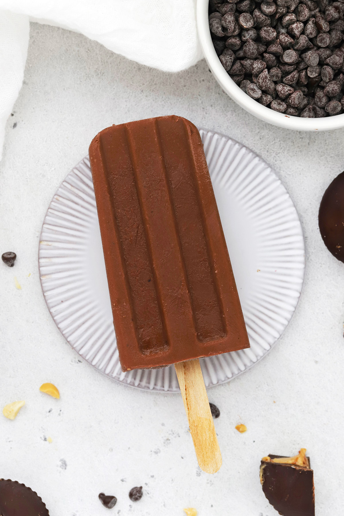 Overhead view of a chocolate peanut butter popsicle on a coaster