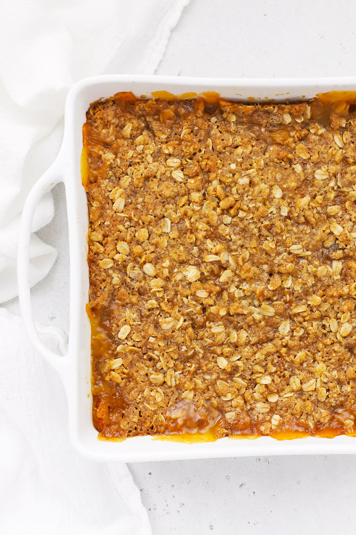 Gluten-Free peach crisp in a white baking dish fresh from the oven
