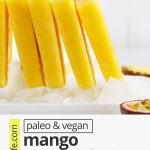 Front view of a row of mango passion fruit popsicles standing up on a plate of ice with text overlay that reads paleo & vegan mango passion fruit popsicles: 3-ingredients + healthy + delicious"