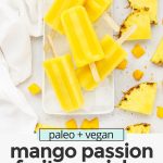 Overhead view of mango passion fruit popsicles stacked on a plate of ice with text overlay that reads paleo & vegan mango passion fruit popsicles: 3-ingredients + healthy"