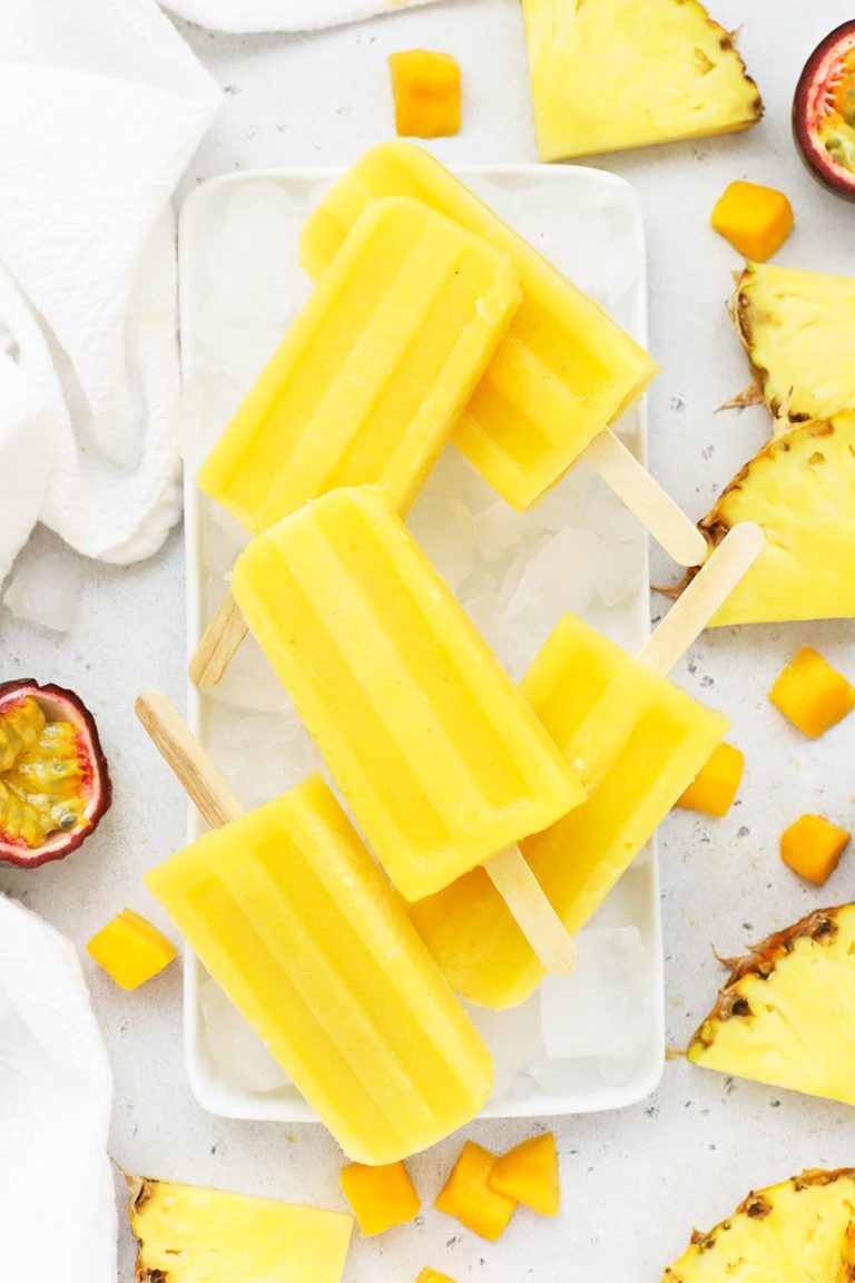 Overhead view of mango passion fruit popsicles stacked on a plate of ice