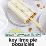 Front view of healthy key lime pie popsicles garnished with graham cracker crumbs and lime zest on a white background with text overlay that reads "gluten-free + vegan-friendly key lime pie popsicles: creamy + fresh + sweet + tart"