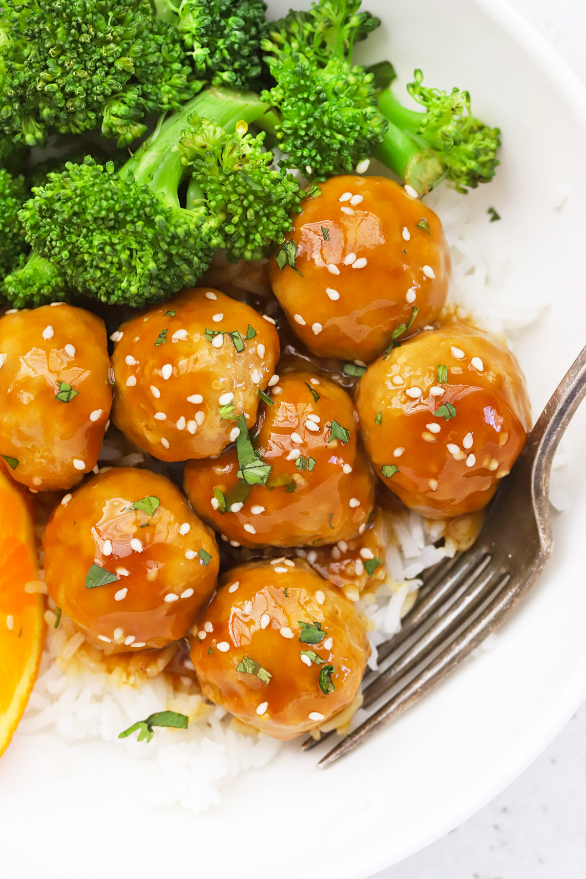 Close up overhead view of healthy orange chicken meatballs with rice and steamed broccoli