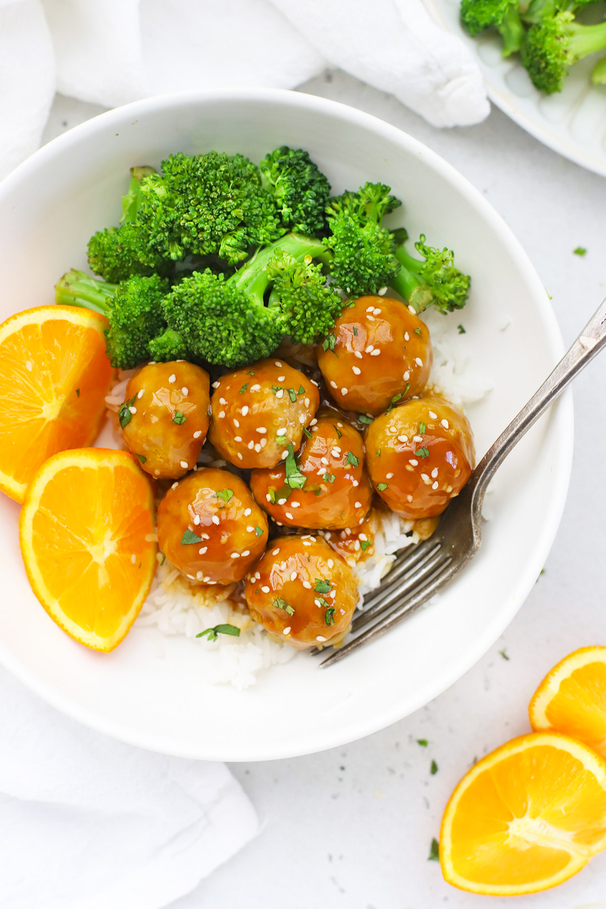 Overhead view of healthy orange chicken meatballs with rice and steamed broccoli