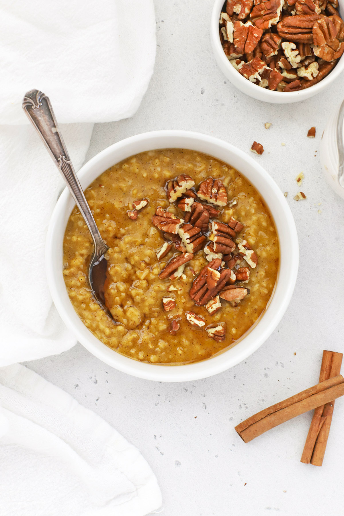 Overhead view of a bowl of Instant Pot Pumpkin Steel Cut Oats topped with maple syrup and pecans