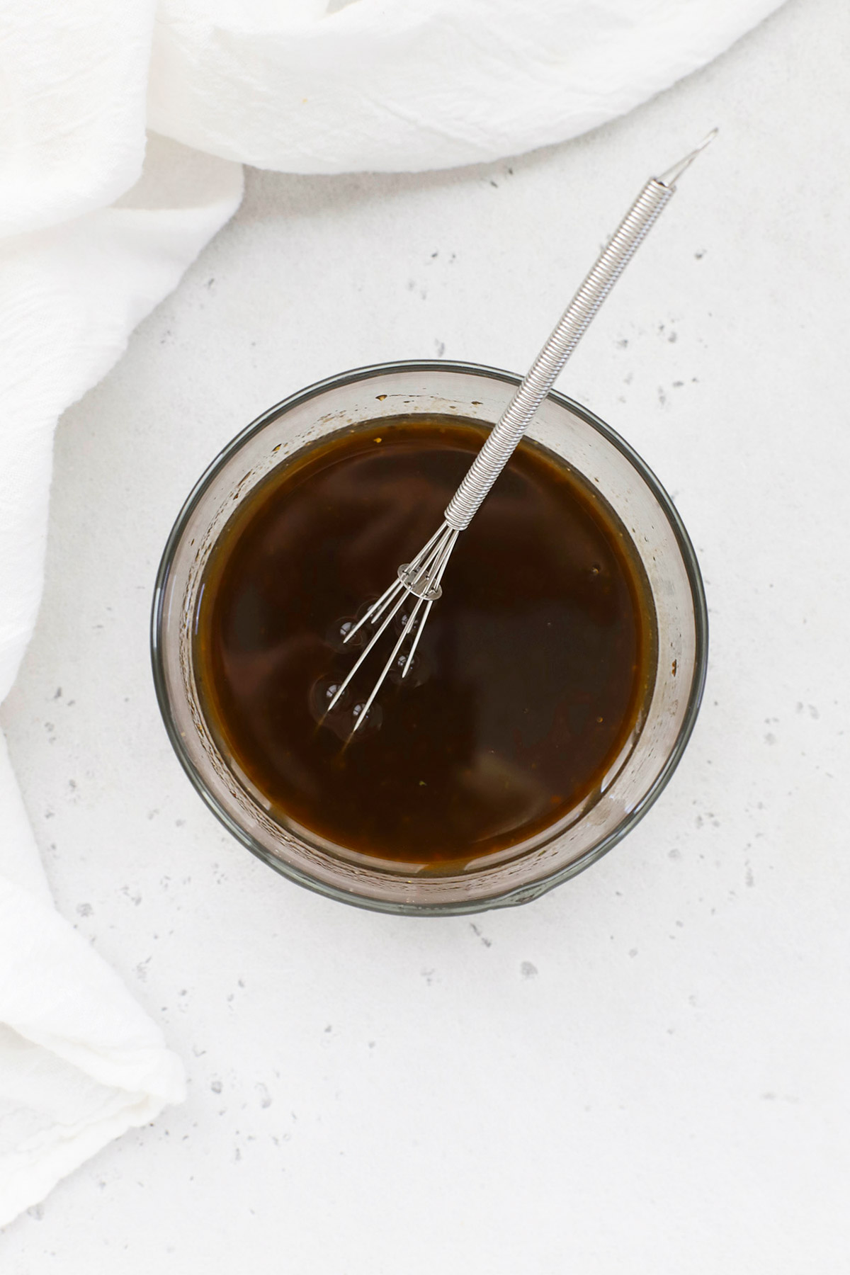 Overhead view of a glass bowl of balsamic dressing for powerhouse quinoa salad
