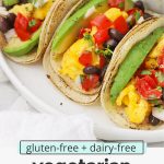Front view of a platter of three healthy vegetarian breakfast tacos with text overlay that reads "gluten-free + dairy-free vegetarian breakfast tacos: quick + easy + full of flavor!"