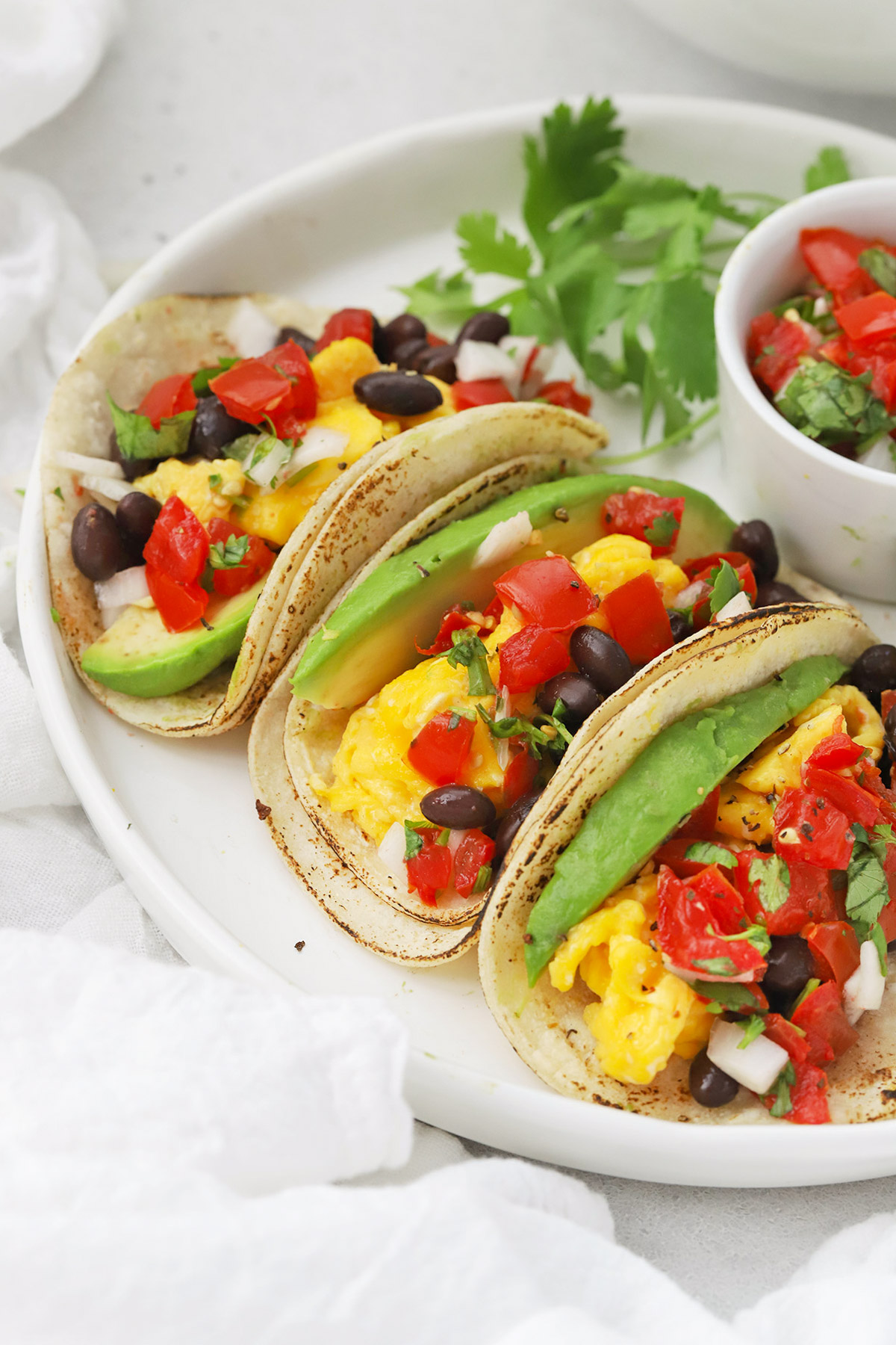 Front view of a platter of three healthy vegetarian breakfast tacos
