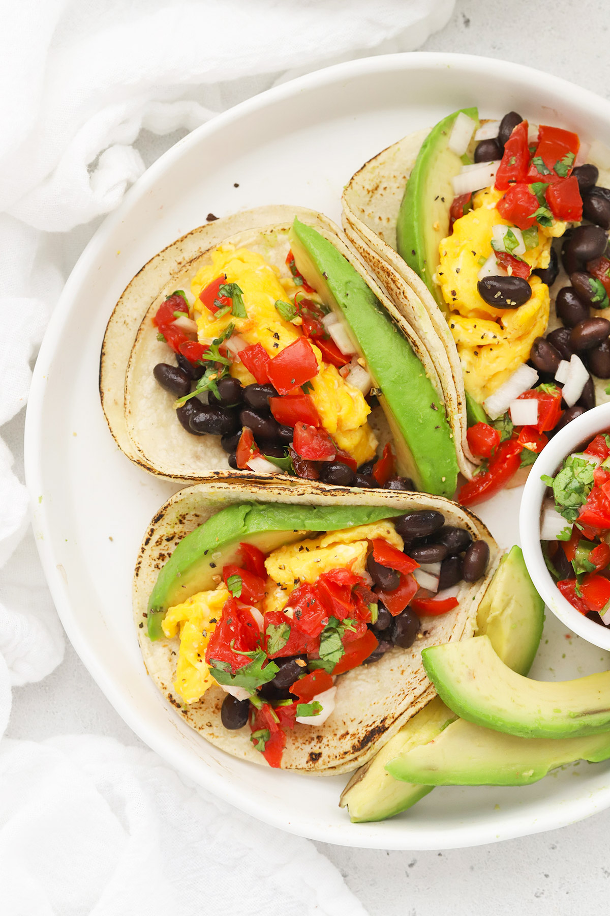 Overhead view of a platter of three healthy vegetarian breakfast tacos