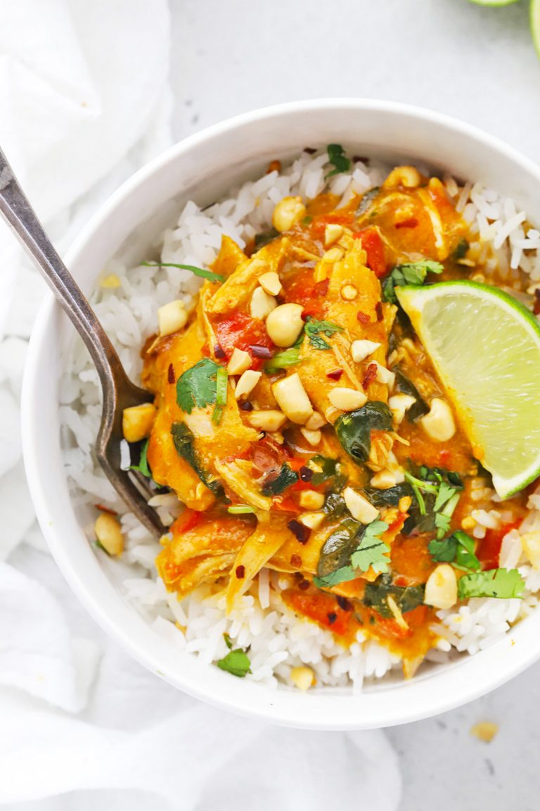 Close up overhead view of Healthy pumpkin chicken curry topped with crushed peanuts and fresh cilantro