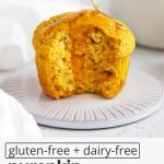 Overhead view of a gluten-free pumpkin muffin with a bite out of it, drizzled with honey with text overlay that reads "gluten-free + dairy-free pumpkin cornbread muffins: light + fluffy + delightful"