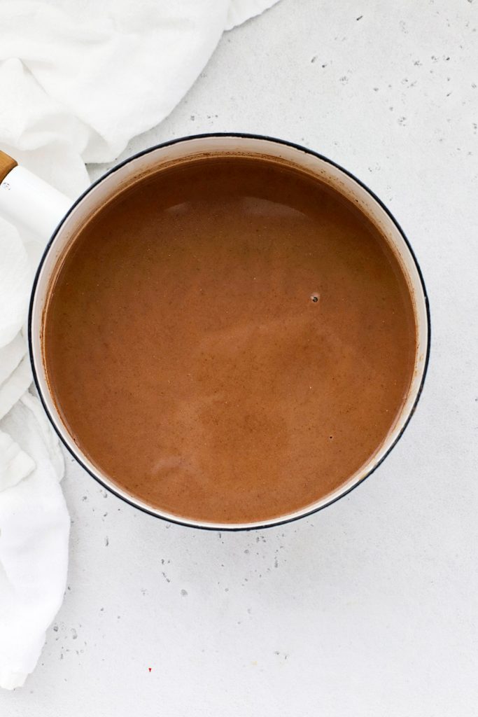 Overhead view of a steaming pan of dairy-free pumpkin spice hot chocolate