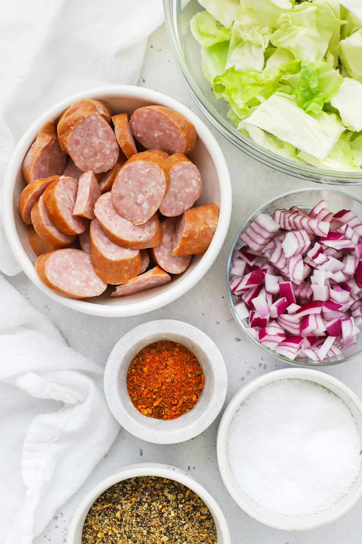 Overhead view of ingredients for a sausage & cabbage skillet dinner