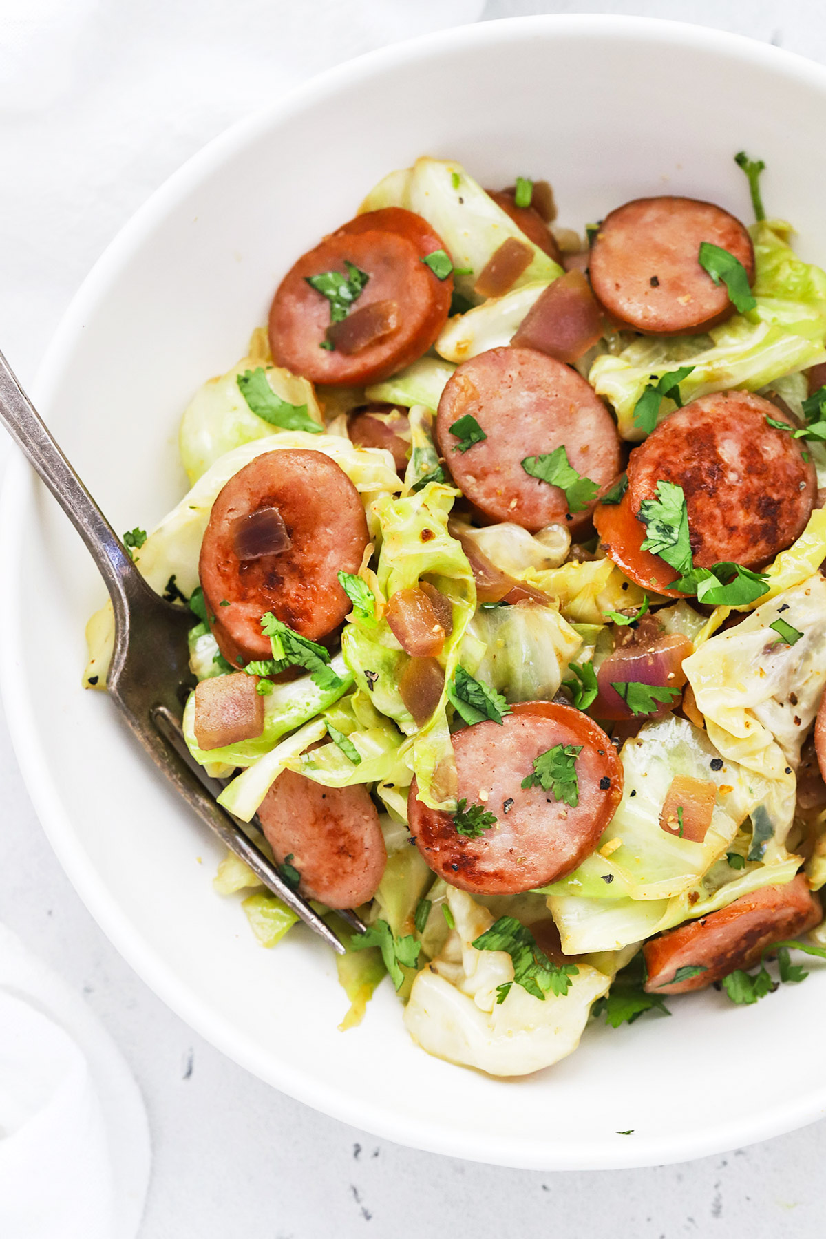 Close up Overhead view of a bowl of one pot sausage and cabbage skillet.