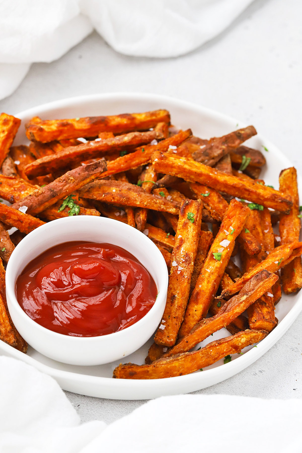 Front view of crispy baked sweet potato fries with ketchup on the side
