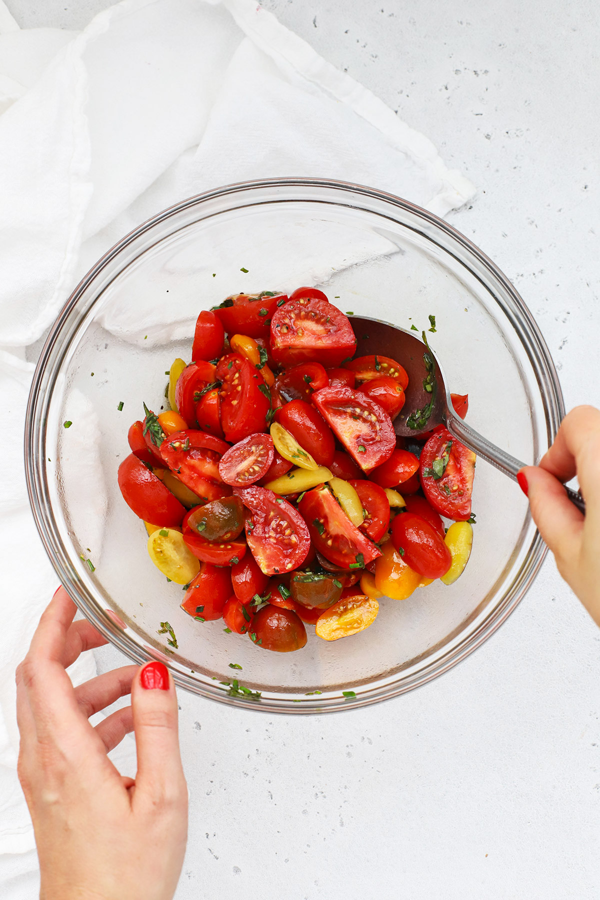 Overhead view of balsamic marinated tomatoes with fresh herbs