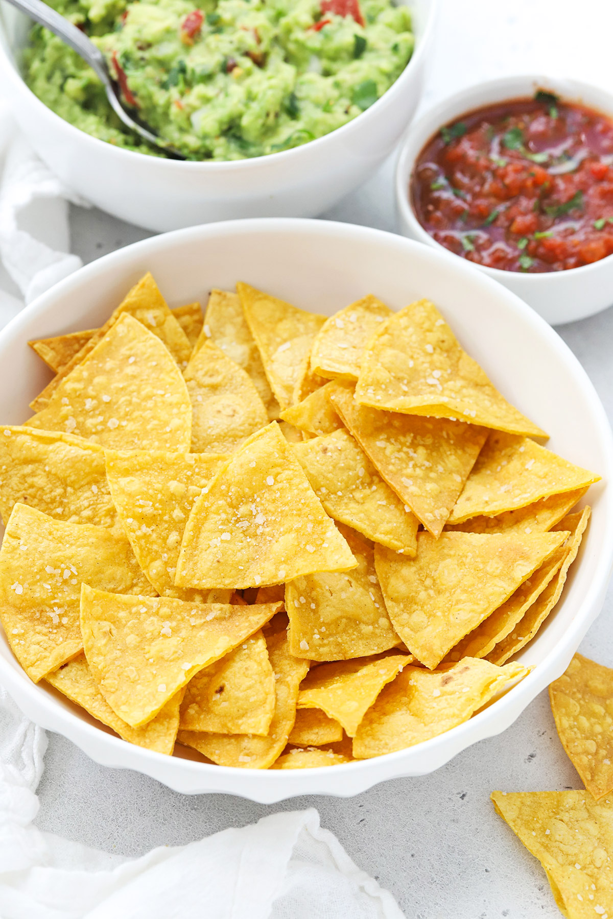 Front view of homemade baked tortilla chips with salt, served with salsa & guacamole