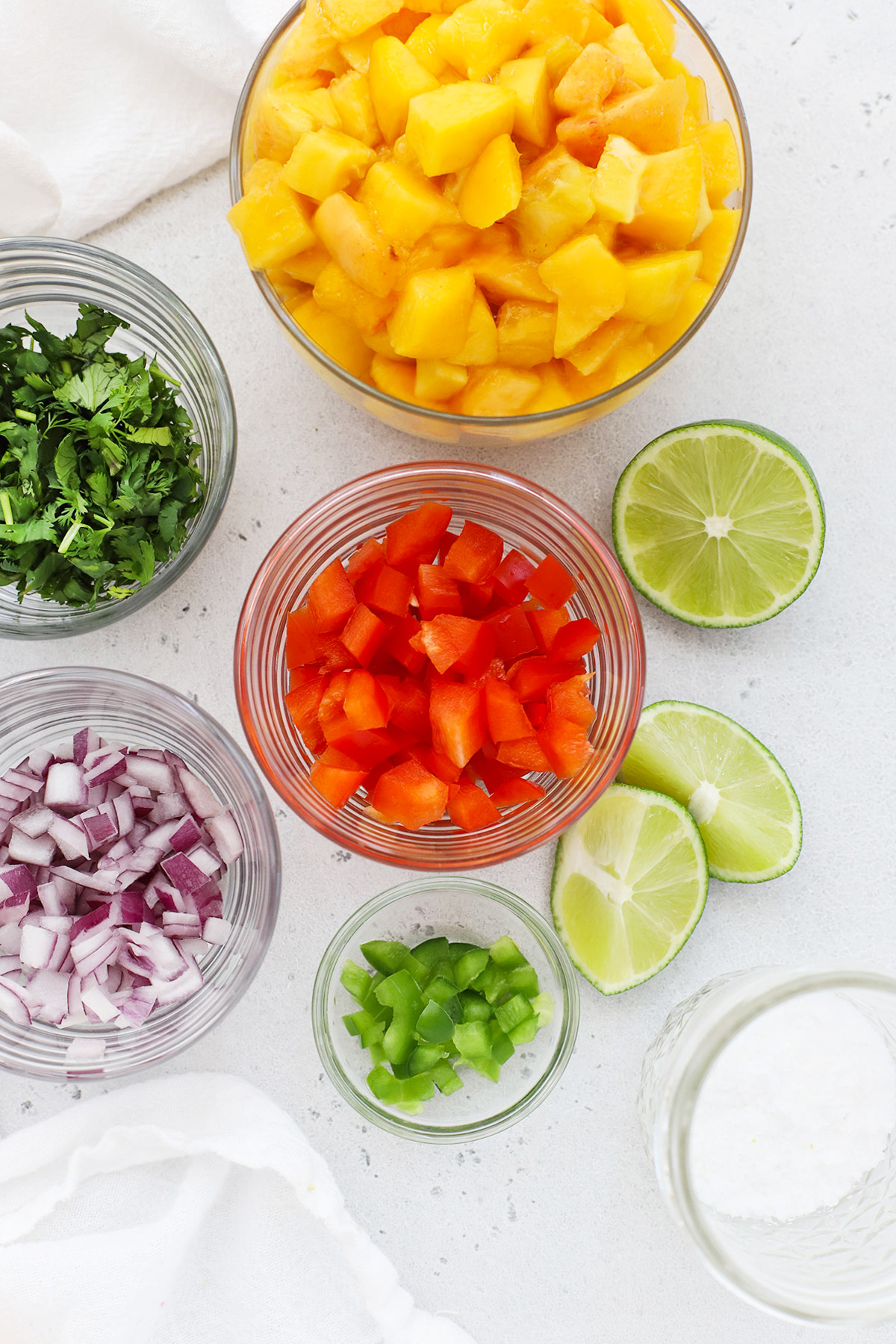 Overhead view of bowls of ingredients for fresh peach salsa