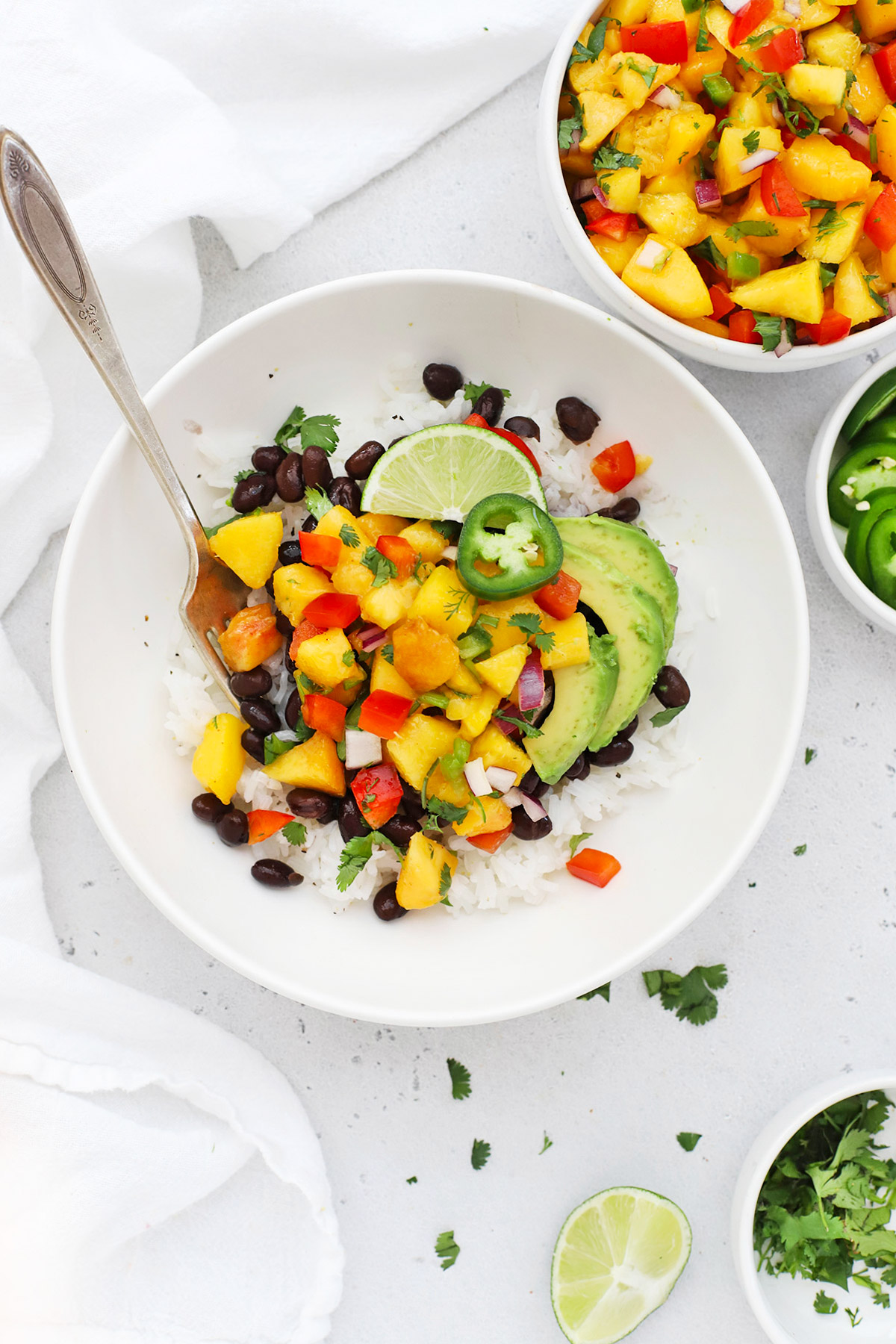 Overhead view of a peach salsa rice bowl with black beans and avocado