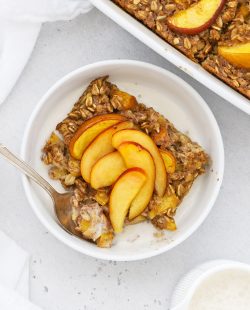Overhead view of a slice of gluten-free peach baked oatmeal topped with fresh peach slices