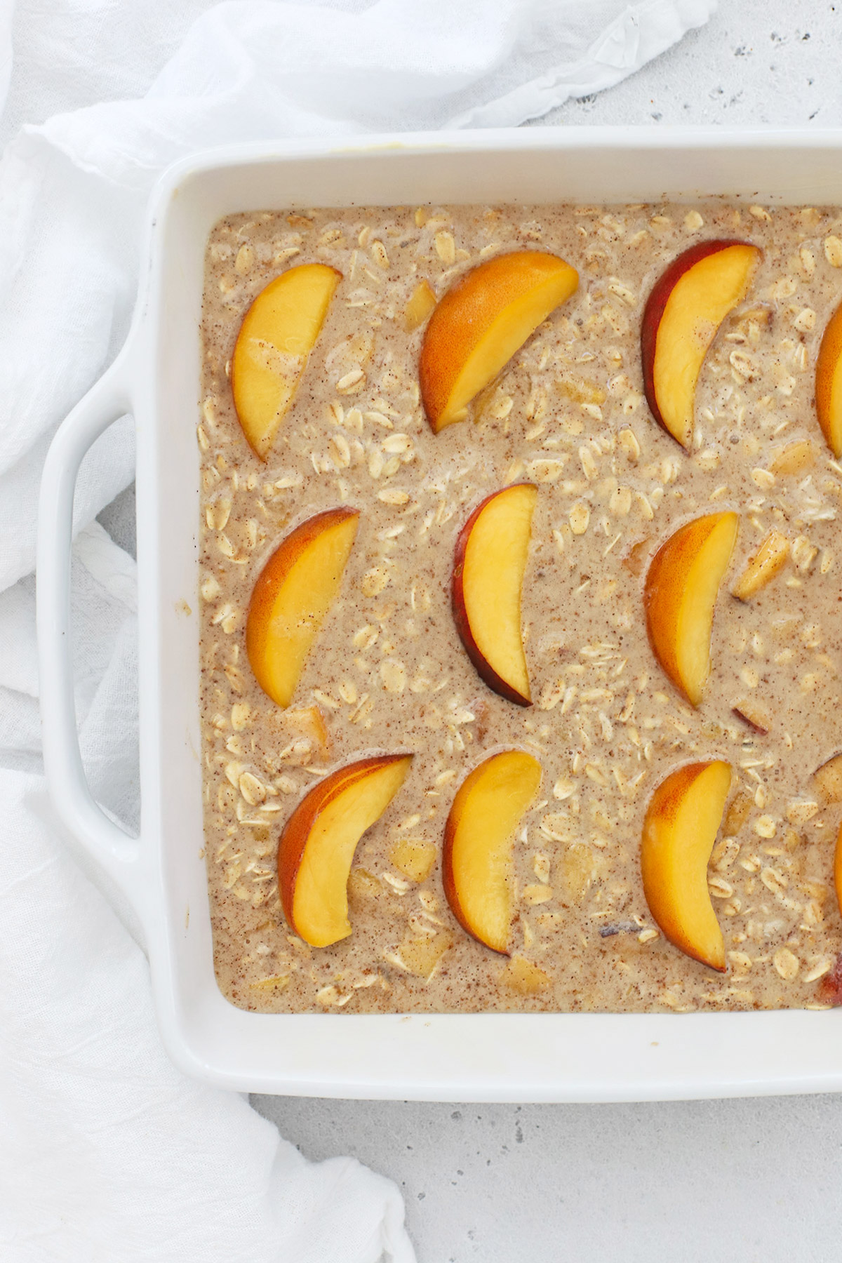 A pan of peach baked oatmeal ready to go into the oven