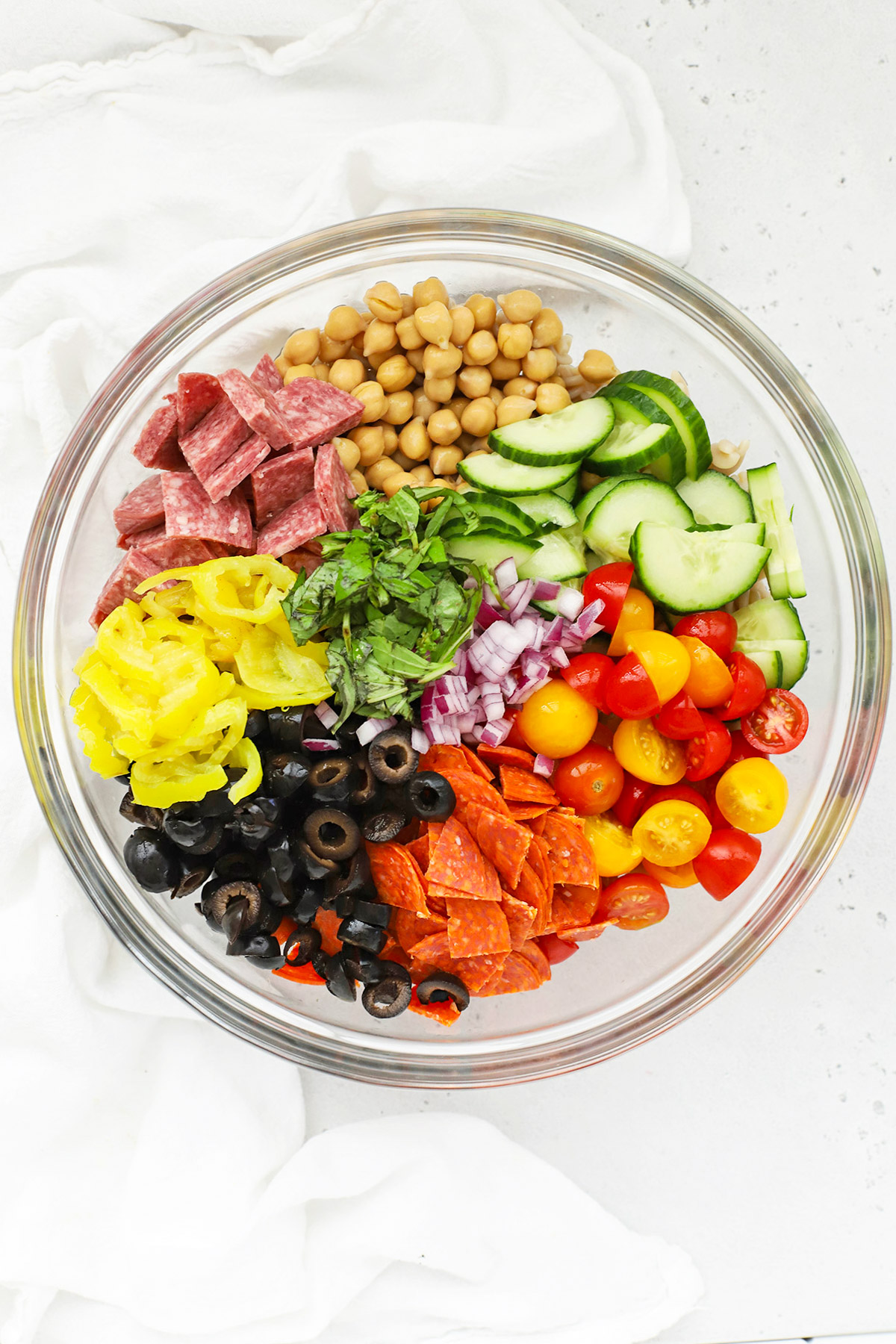 Overhead view of mix-ins added to gluten-free pasta to make gluten-free pasta salad