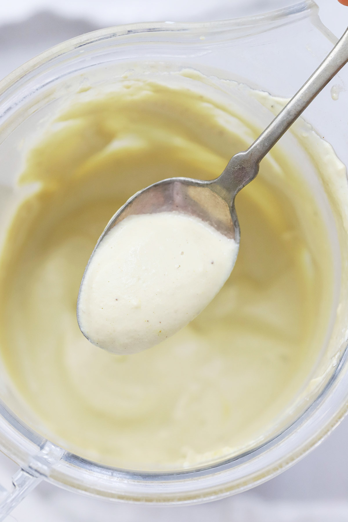 A spoon showing vegan queso blanco