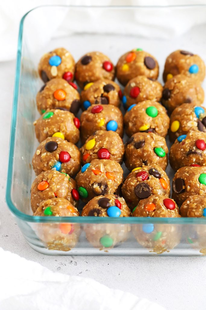Front view of a glass container of peanut butter monster cookie energy bites with m&ms