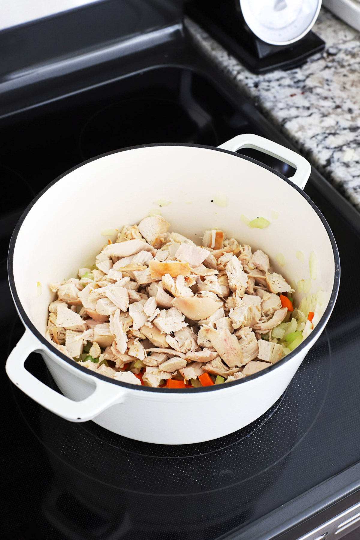 Adding chicken to a pot to make gluten-free chicken soup