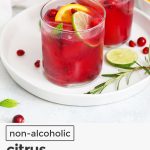 bright red pomegranate mocktails with citrus slices
