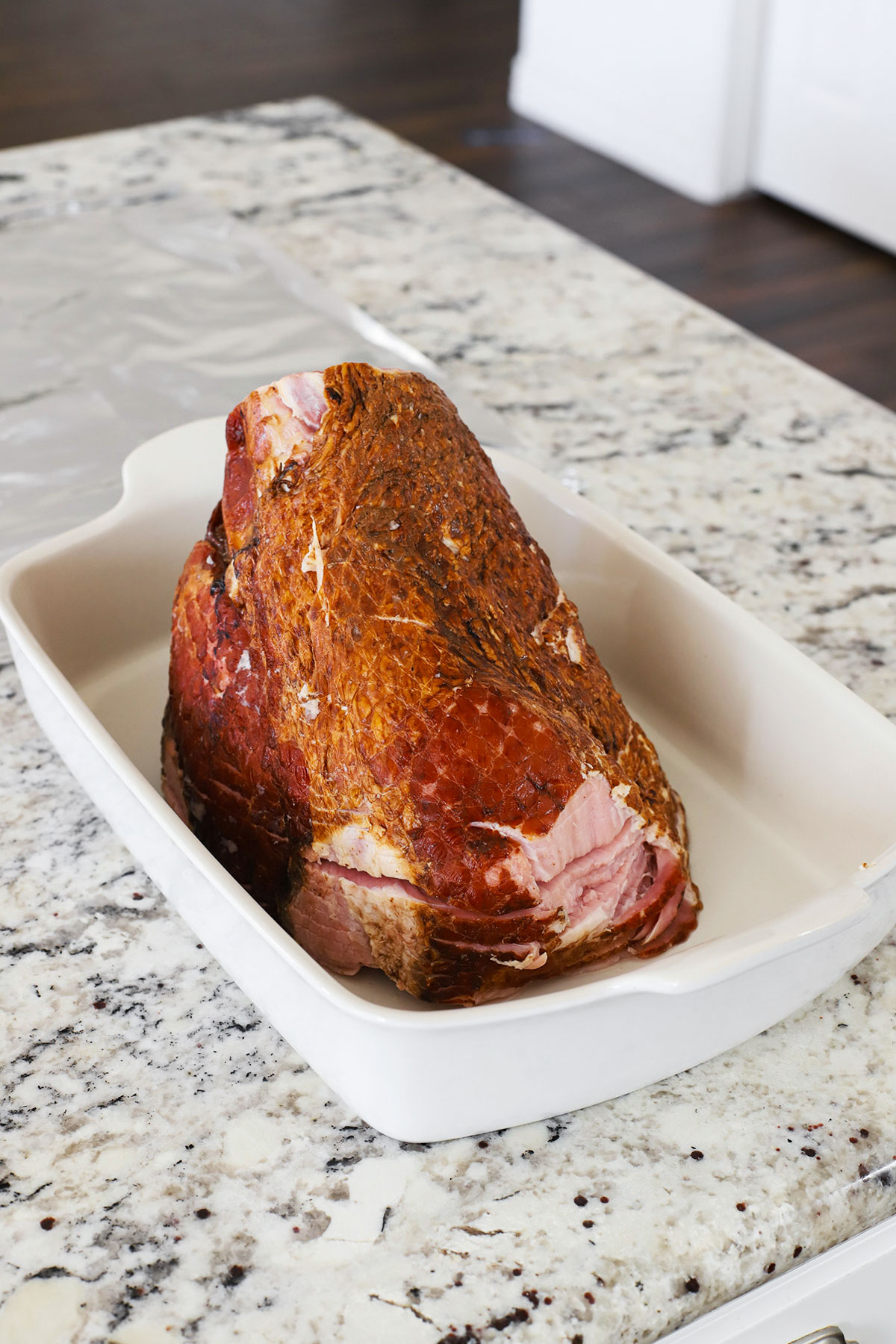 Front view of a ham cut-side down in a roasting pan