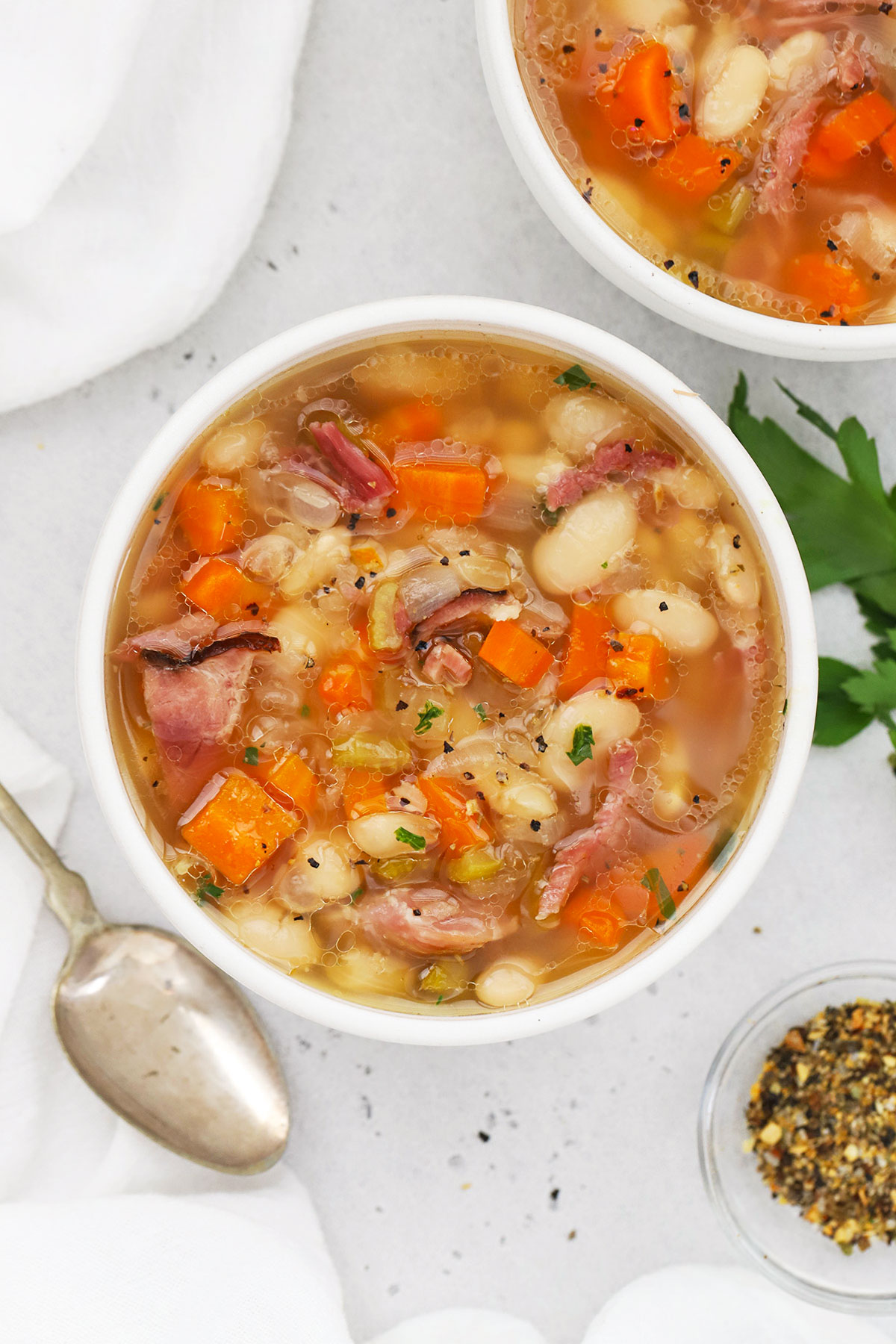 two bowls of slow cooker ham and bean soup on a white background