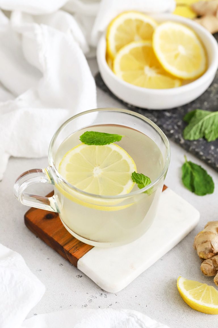 Glass mug of lemon ginger herbal tea with fresh mint