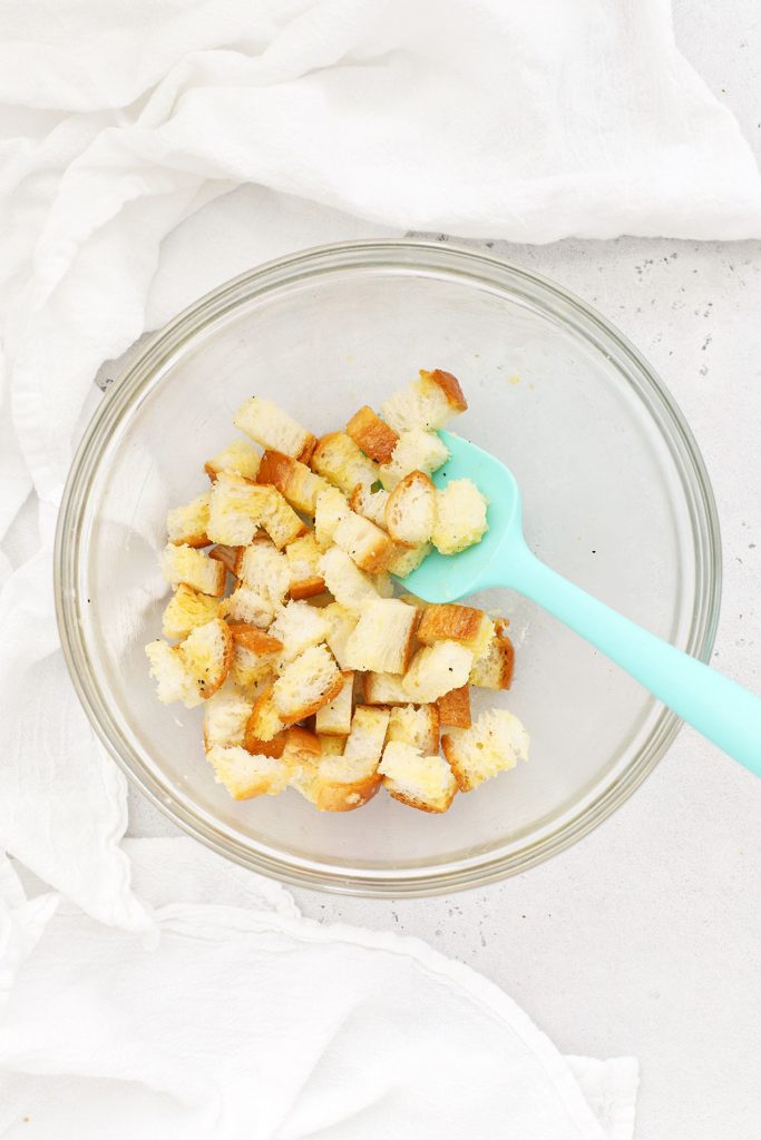 stirring bread cubes with butter to make gluten-free croutons