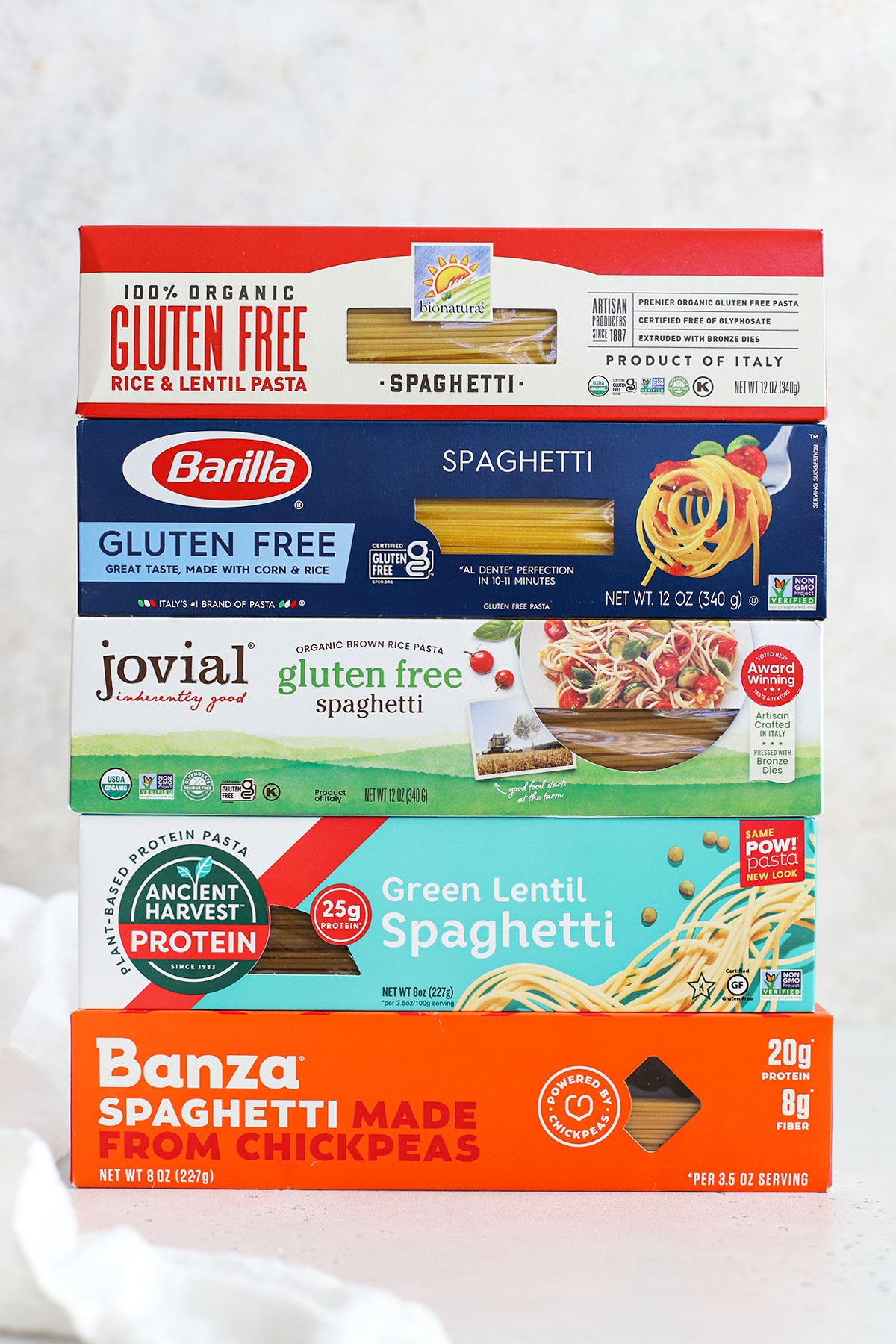 Different boxes of gluten-free spaghetti noodles stacked on top of each other