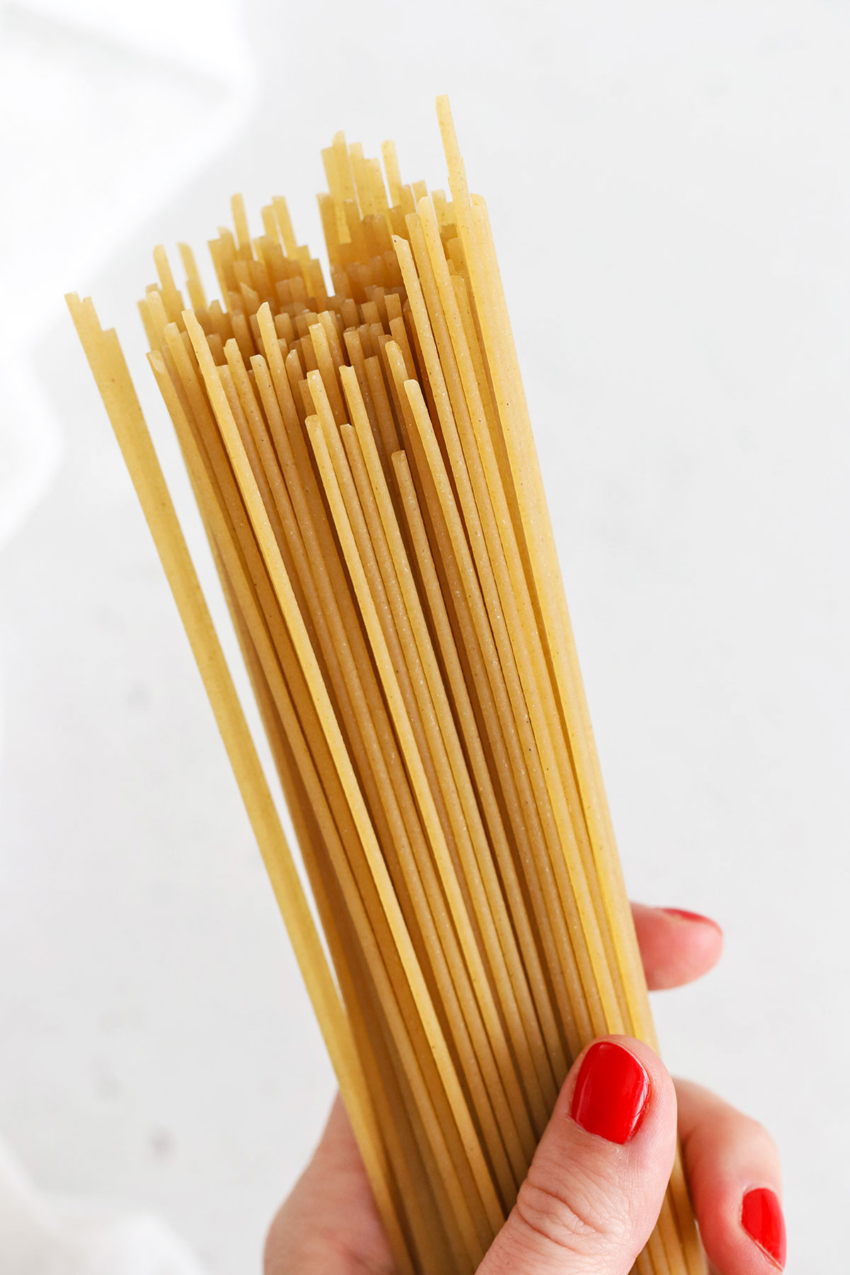 Hand holding gluten-free spaghetti noodles