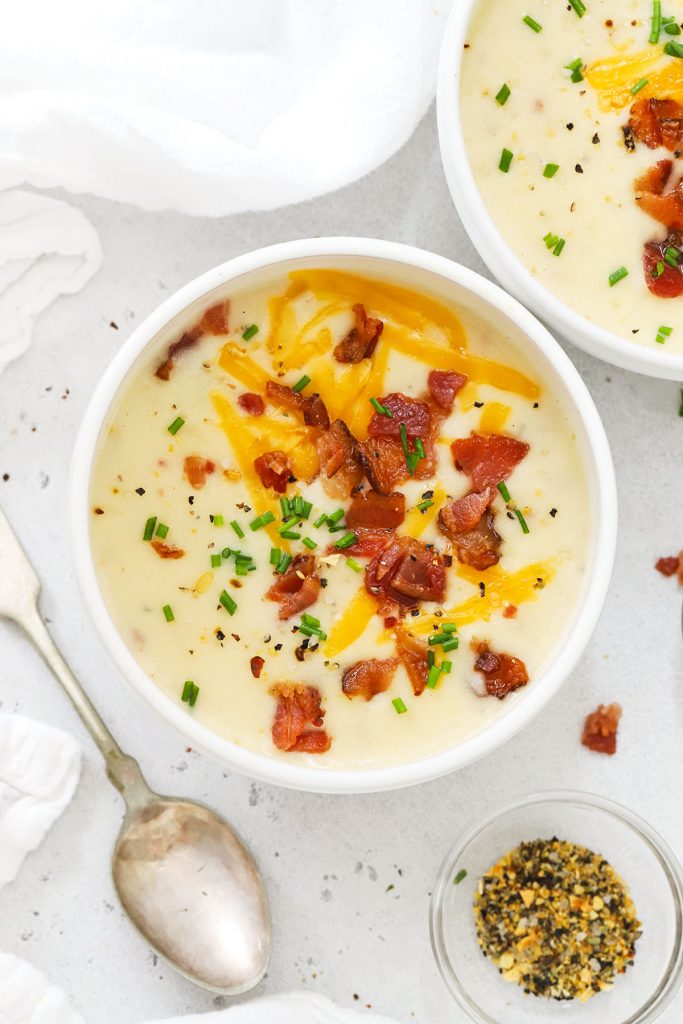 gluten free potato soup topped with cheddar cheese, bacon bits, and chives