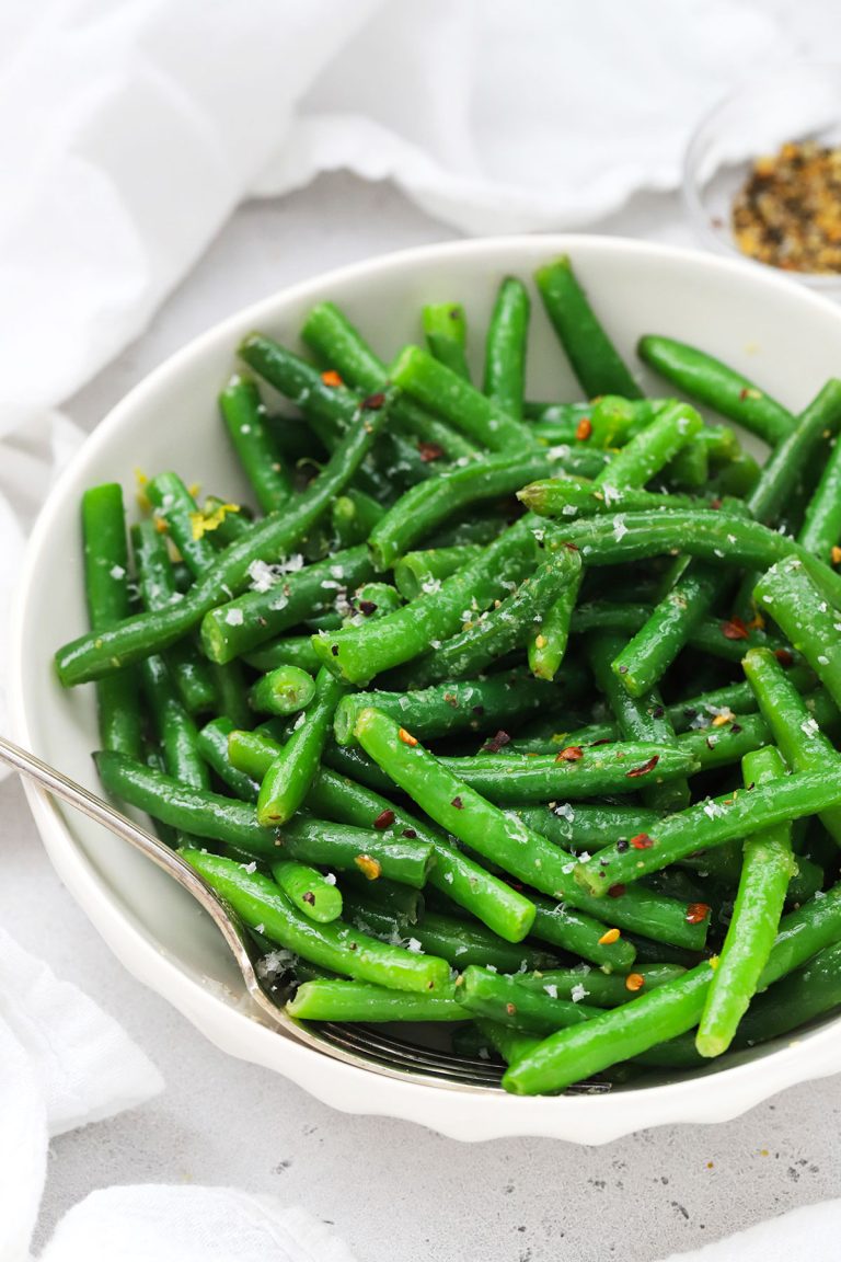 Front view of seasoned green beans in a white bowl