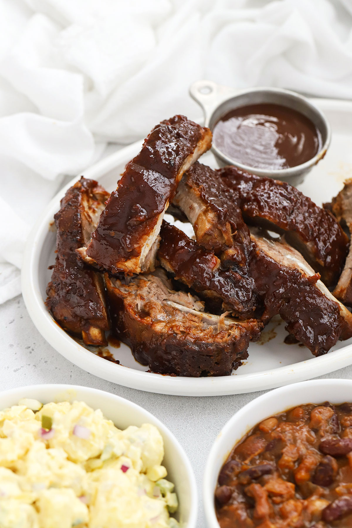 crock pot ribs on a white platter with barbecue sauce