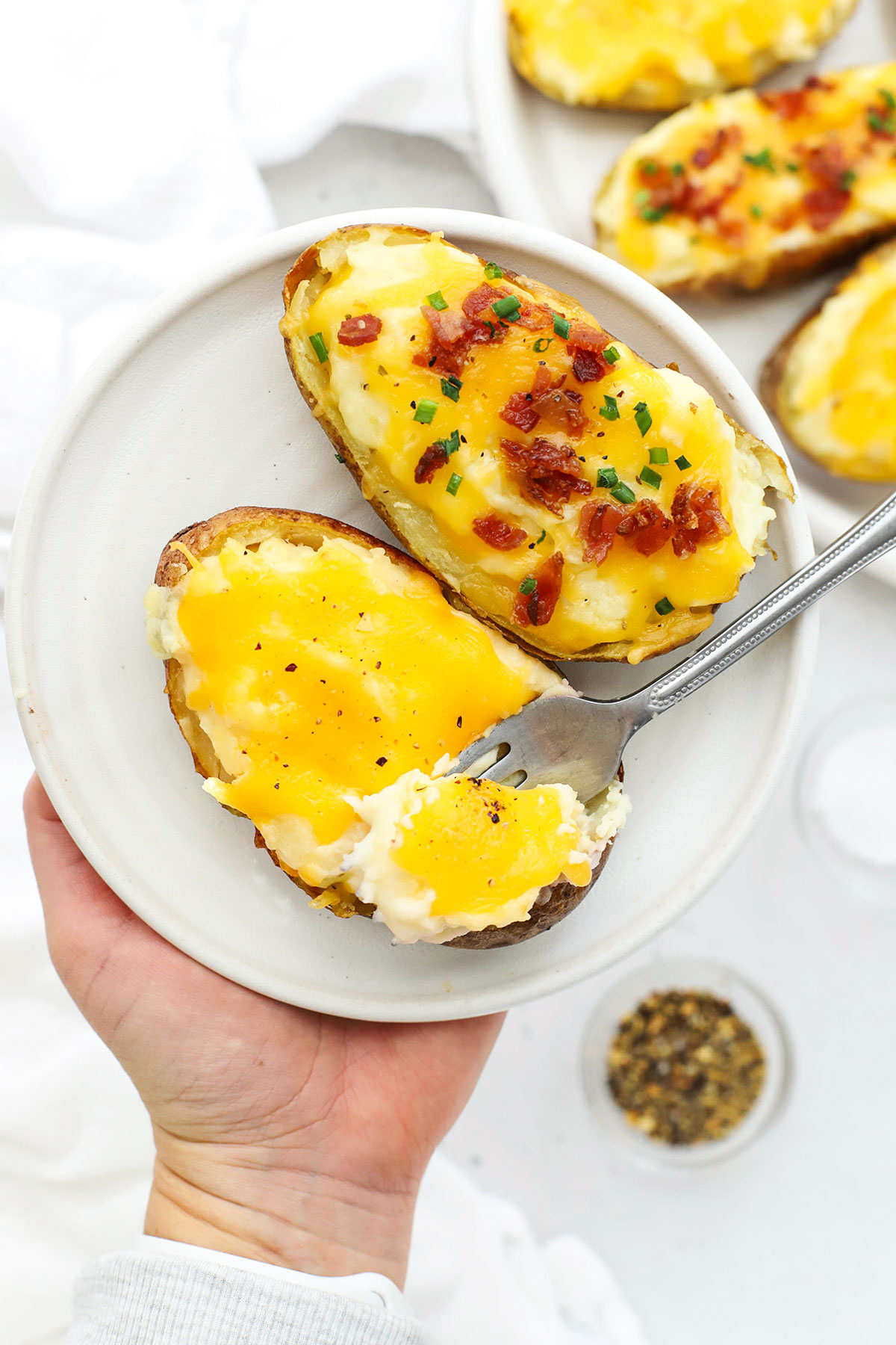 Our Twice Baked Potatoes recipe is a popular side dish that's delicious with all sorts of dinners. Don't miss all our favorite add-ins and toppings to try! / easy twice-baked potatoes recipe / gluten-free twice baked potatoes recipe / twice baked potatoes with cheese / twice baked potatoes with bacon / the best twice baked potatoes recipe / easter side dish / easter potatoes / thanksgiving side dish / thanksgiving potatoes /