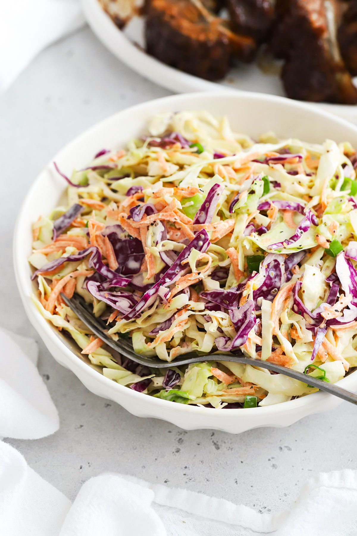 gluten-free coleslaw in a white bowl with creamy dressing