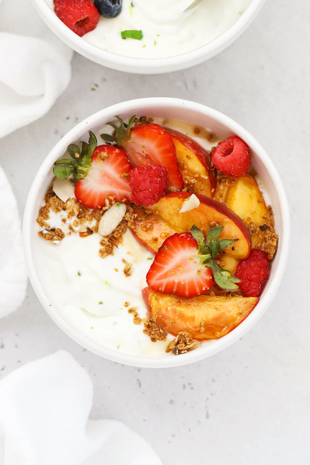 lime greek yogurt topped with peaches and berries