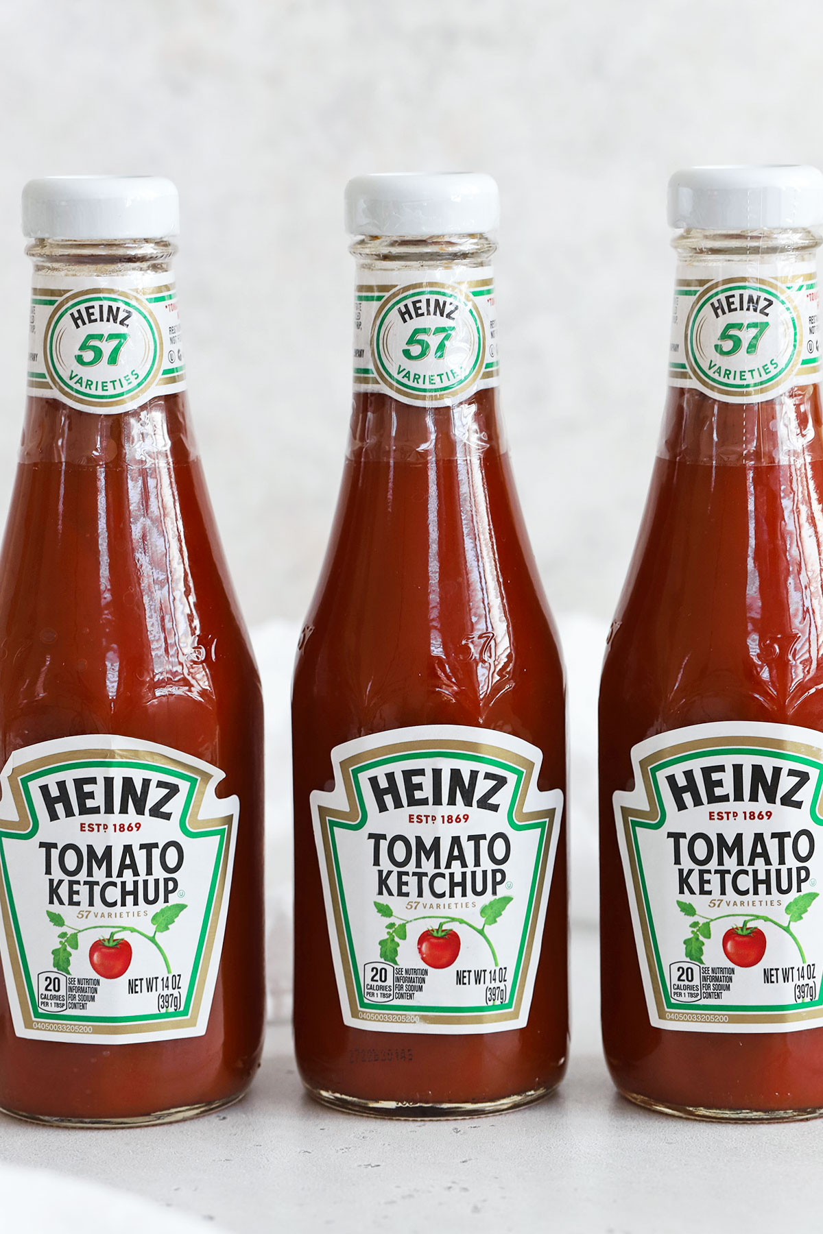 three bottles of heinz ketchup on a white background