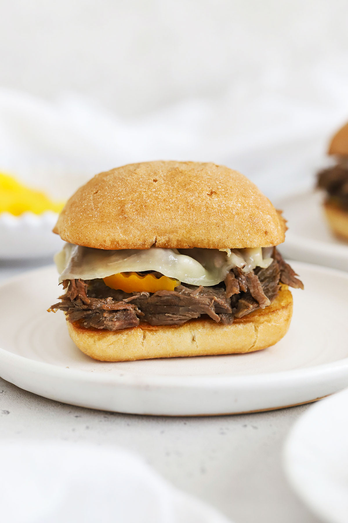 Slow cooker italian beef sandwich with peperoncinis and provolone cheese
